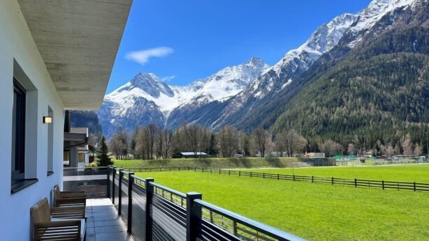 A balcony with a view of a green field and snow-capped mountains. - Apartment Aiko by Interhome (Längenfeld)