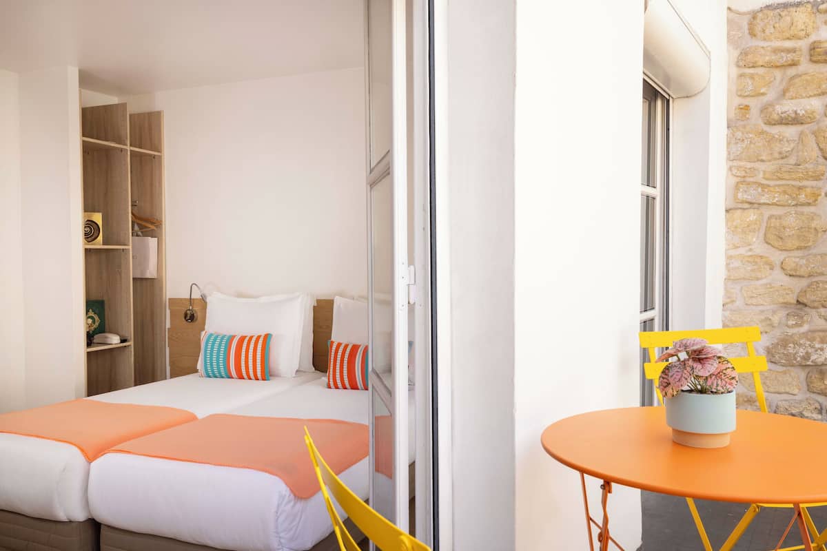 A bedroom with a bed, a wardrobe, and a small table with a plant.