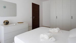 A hotel room with a bed, a dresser, a wardrobe, and a mirror.