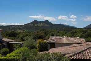 Ein Gebäude mit einem Ziegeldach und Blick auf ein Gebirge.