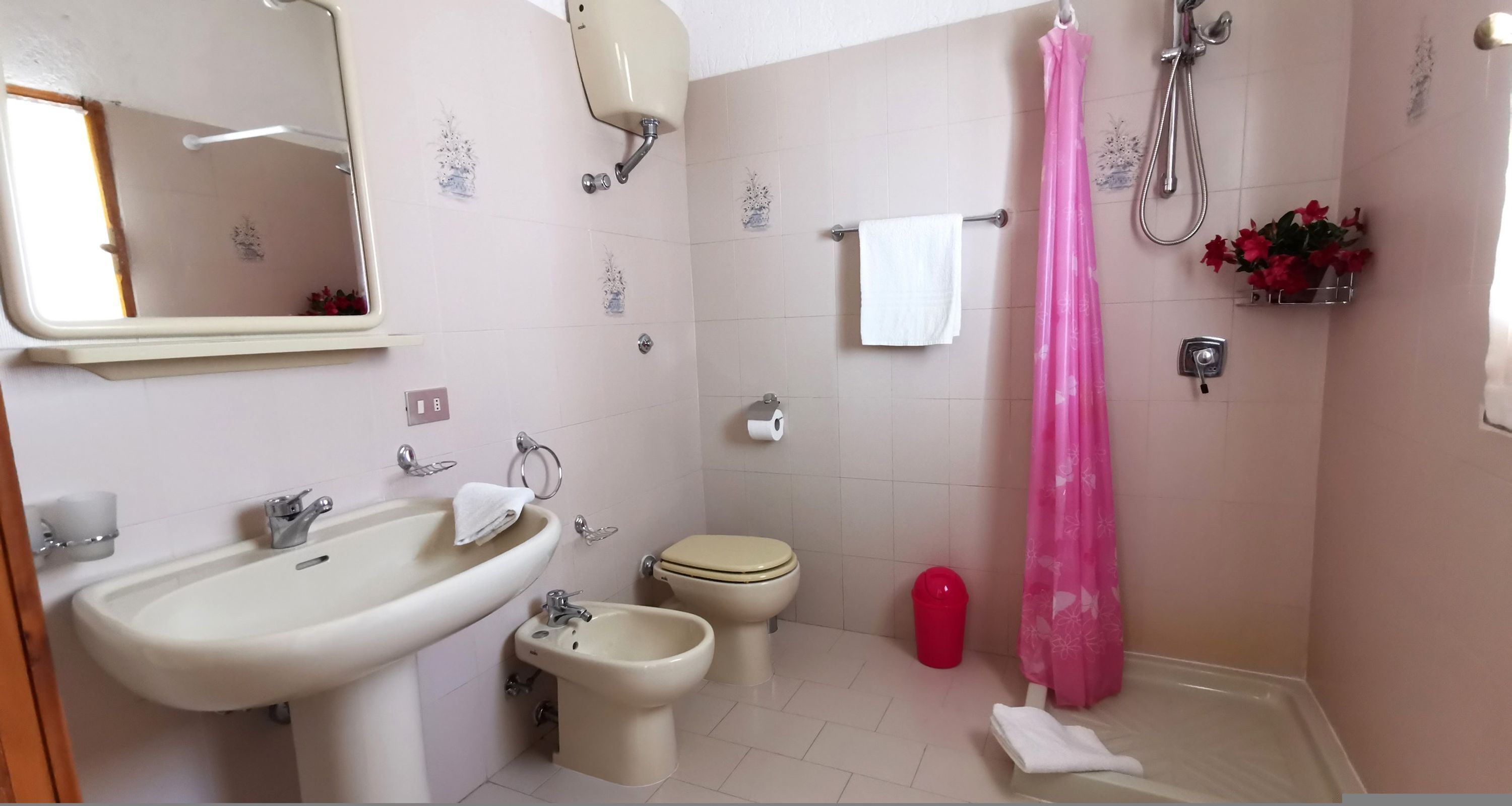 Un baño con lavamanos, bidé, inodoro y ducha.