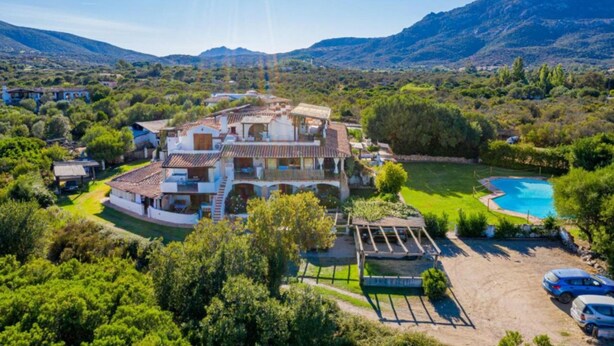 A large villa with multiple levels, a swimming pool, and a surrounding landscaped garden. - Welcomely - Le Vele in Olbia (Olbia)