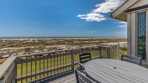 A balcony with a view of the beach and ocean.