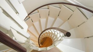 Una escalera de caracol con barandillas blancas y un pasamanos de madera.