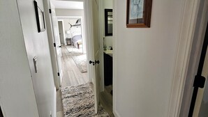 A hallway with a carpet, a framed picture on the wall, and a door leading to another room. - Fishing / Hunting / Boating - Dream Location -Boats Also Available For Rent  (Grosse Ile Township)