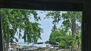 A deck with outdoor seating, a view of a dock with boats, and a grassy area with potted plants. - Fishing / Hunting / Boating - Dream Location -Boats Also Available For Rent  (Grosse Ile Township)