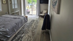A bedroom with a bed, a ceiling fan, a TV, and a view of the outdoors. - Fishing / Hunting / Boating - Dream Location -Boats Also Available For Rent  (Grosse Ile Township)