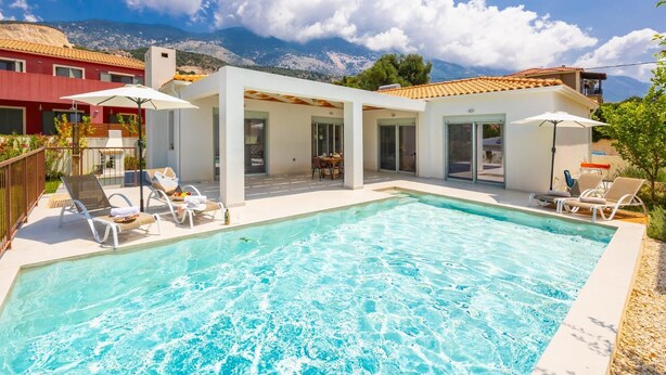 Un área de piscina moderna con sillones de descanso y una alberca.