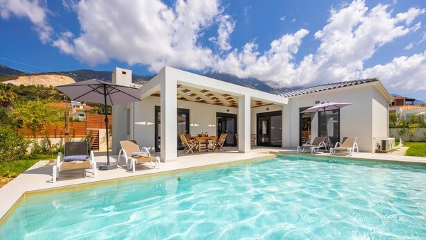 A modern house with a swimming pool, outdoor seating, and a view of mountains. - Villa Petra - Two Bedroom Villa, Sleeps 4 (Afrato)