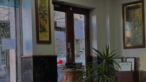 Un espace d’accueil avec des meubles à motifs, une horloge et une grande fenêtre.