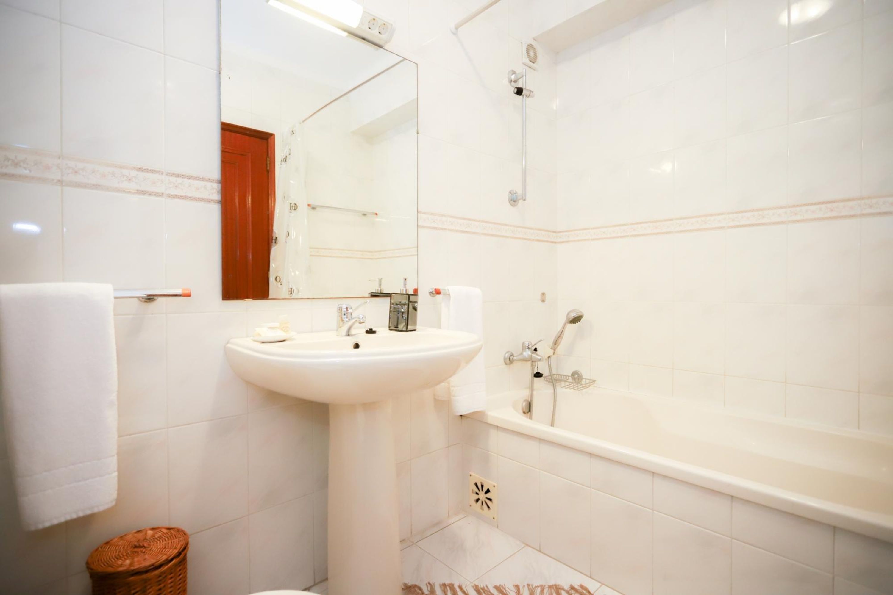 Un baño con lavamanos, espejo y bañera.
