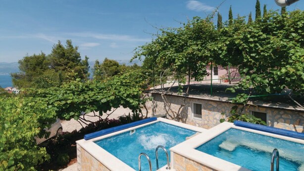 A pool area with two rectangular pools, surrounded by stone walls and lush greenery. - Holiday Home Blossom - Four Bedroom Holiday Home With Outdoor Pool and Jacuzzi - (Supetar)