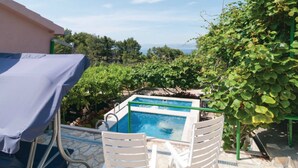 A pool area with a view of the sea, surrounded by greenery and a covered seating area. - Holiday Home Blossom - Four Bedroom Holiday Home With Outdoor Pool and Jacuzzi - (Supetar)