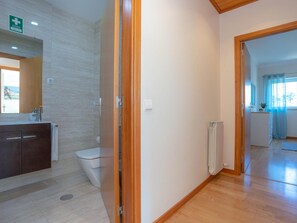 Une salle de bain moderne équipée d’une douche, de toilettes et d’un meuble-lavabo.