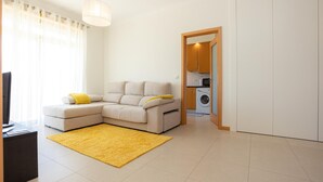 Una sala de estar moderna con un sofá, un tapete amarillo y un televisor.