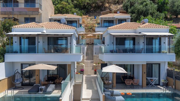 A modern resort with two-story buildings, outdoor pools, and sun loungers. - Vrachos Luxury Maisonettes (Parga)