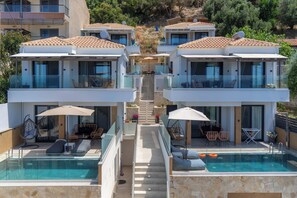 A modern resort with two-story buildings, outdoor pools, and sun loungers.