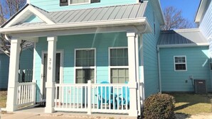 A two-story house with a porch, a garage, and a small front yard.