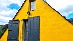 A yellow building with a small window and a door, a ramp leading to the entrance, and a power outlet on the wall. - Ferienhaus in Barenstein bei Grunen Hugeln (Baerenstein)