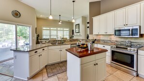 A spacious kitchen with white cabinets, a large island, stainless steel appliances, and pendant lighting. - Hilton Head Island Resort Home w/ Fire Pit! (Hilton Head Island)