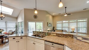 A modern kitchen with white cabinetry, granite countertops, a dishwasher, and a skylight. - Hilton Head Island Resort Home w/ Fire Pit! (Hilton Head Island)