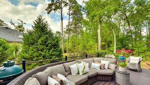 A deck with a wicker sofa, a round table, and a chair. - Hilton Head Island Resort Home w/ Fire Pit! (Hilton Head Island)