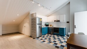 Une cuisine moderne avec des armoires blanches, des touches de bleu et un carrelage à motifs.
