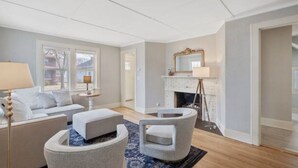 A modern living room with a fireplace, a sofa, a coffee table, and a lamp. - Cobblestone Cottage, 4 Bedroom, centrally located (La Crosse)