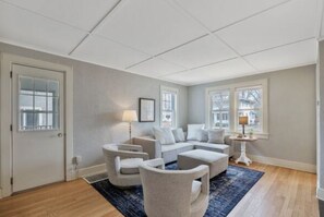 A modern living room with a sectional sofa, two armchairs, a coffee table, and a rug.