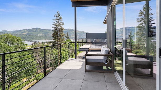 Ein Balkon mit Blick auf Berge und einen Fluss.