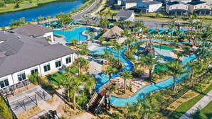 Un quartier résidentiel doté d’une grande piscine, de plusieurs bâtiments et d’un lac en arrière-plan.