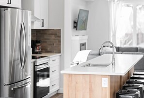 Fridge, dishwasher, coffee/tea maker, cookware/dishes/utensils