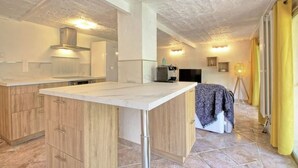 Une cuisine moderne avec des meubles en bois, un plan de travail en marbre et une cuisinière intégrée.