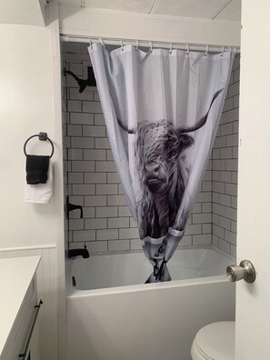 Een douche, handdoeken, zeep, toiletpapier