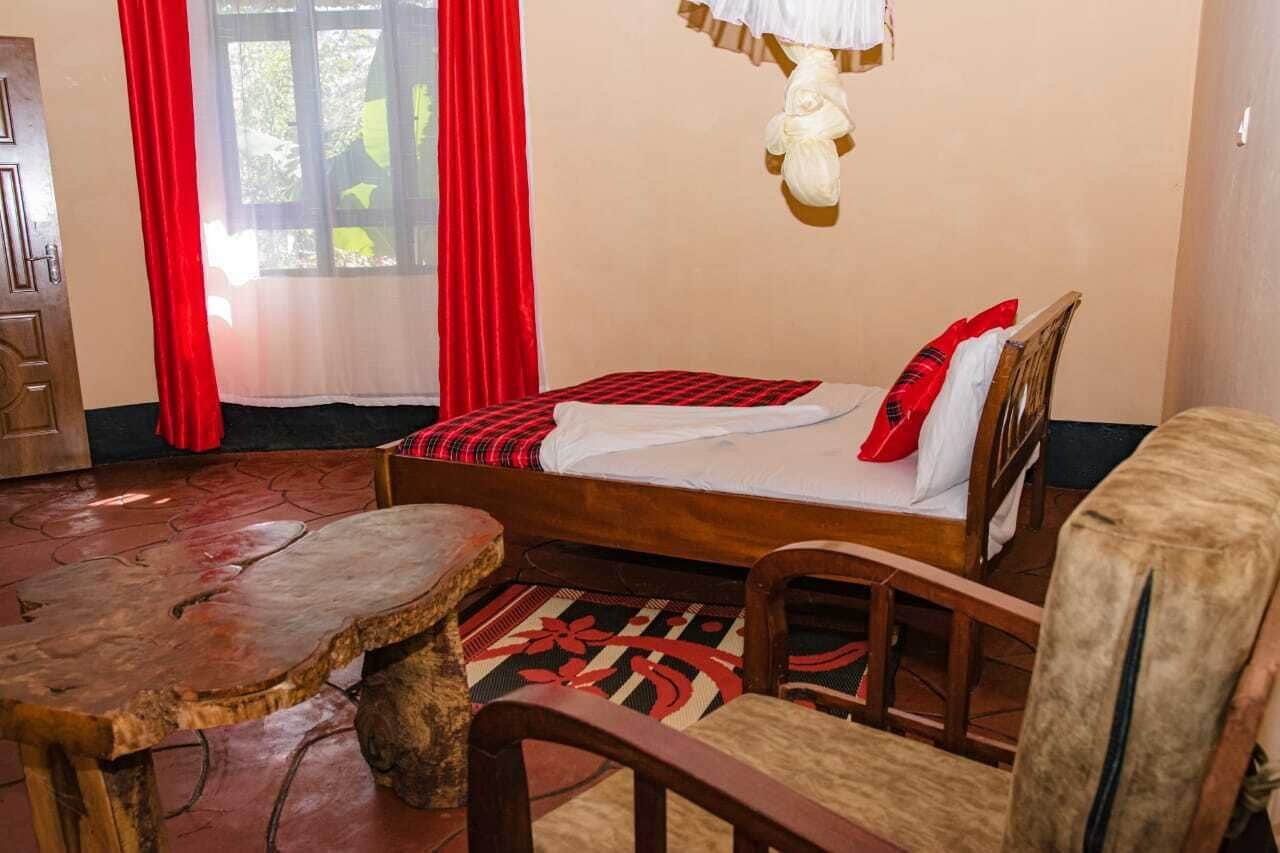 A room with a bed, a wooden table, and a chair.