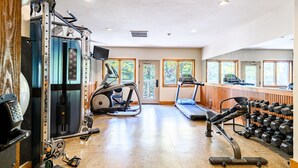Een sportschool met trainingsapparatuur, loopbanden en gewichten.