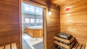 Een houten interieur met een sauna, een houten bank en een bord dat het sauna gebied aangeeft.