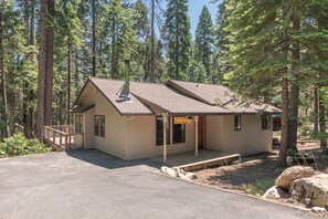 A cabin with a chimney, a deck, and a sign reading 'Lucky Cabin 429 Yuroc.'