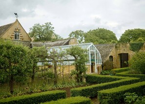 A traditional stone building with a glass greenhouse structure.