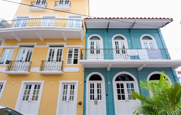 A multi-story building with balconies and arched windows.