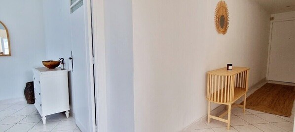 A room with a white cabinet, a wooden side table, and a mirror on the wall. - Bright Appartment, perfect location (Saint-Jean-Cap-Ferrat)