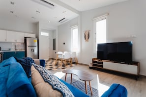 Apartamento Deluxe | Zona de estar | Smart TV de 55 pulgadas con canales digitales, una televisión
