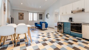 A modern kitchen with white cabinets, a blue countertop, and a checkered floor. - Casa Love 3A (Panama City)