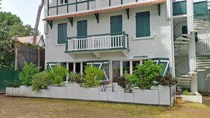 A building with a balcony, a name sign 'CAMBO,' and a white exterior.