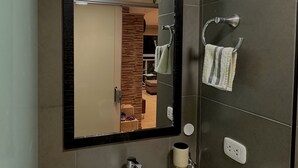 Een badkamer met een wit wastafel, een spiegel en een handdoekrek.