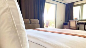 A hotel room with a large bed, a desk, and a chair. - Veronica Guest House (Lomé)