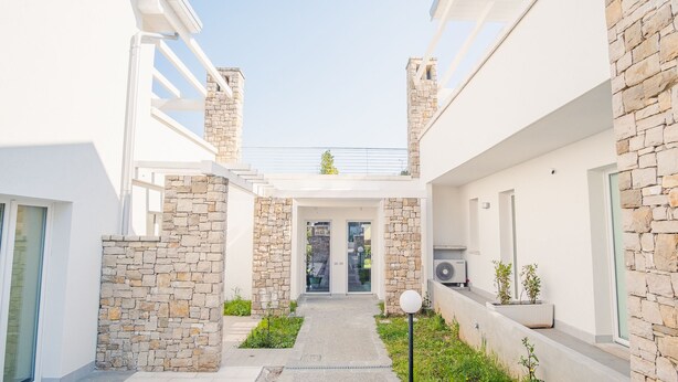 A modern building with stone walls and a central entrance.