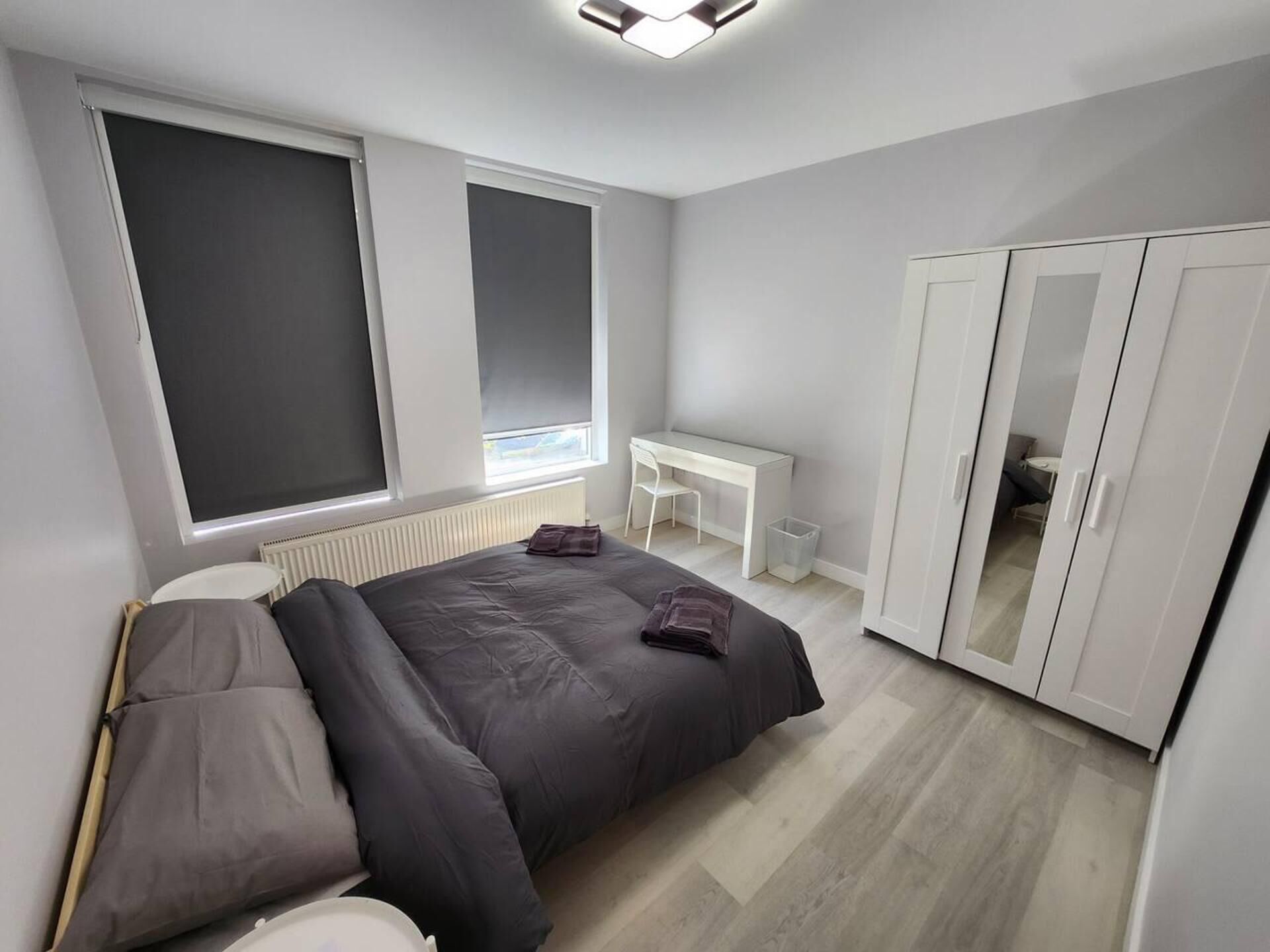 Une chambre moderne avec un lit, un bureau et une armoire.