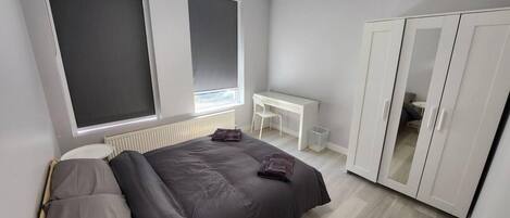 Une chambre moderne avec un lit, un bureau et une armoire.