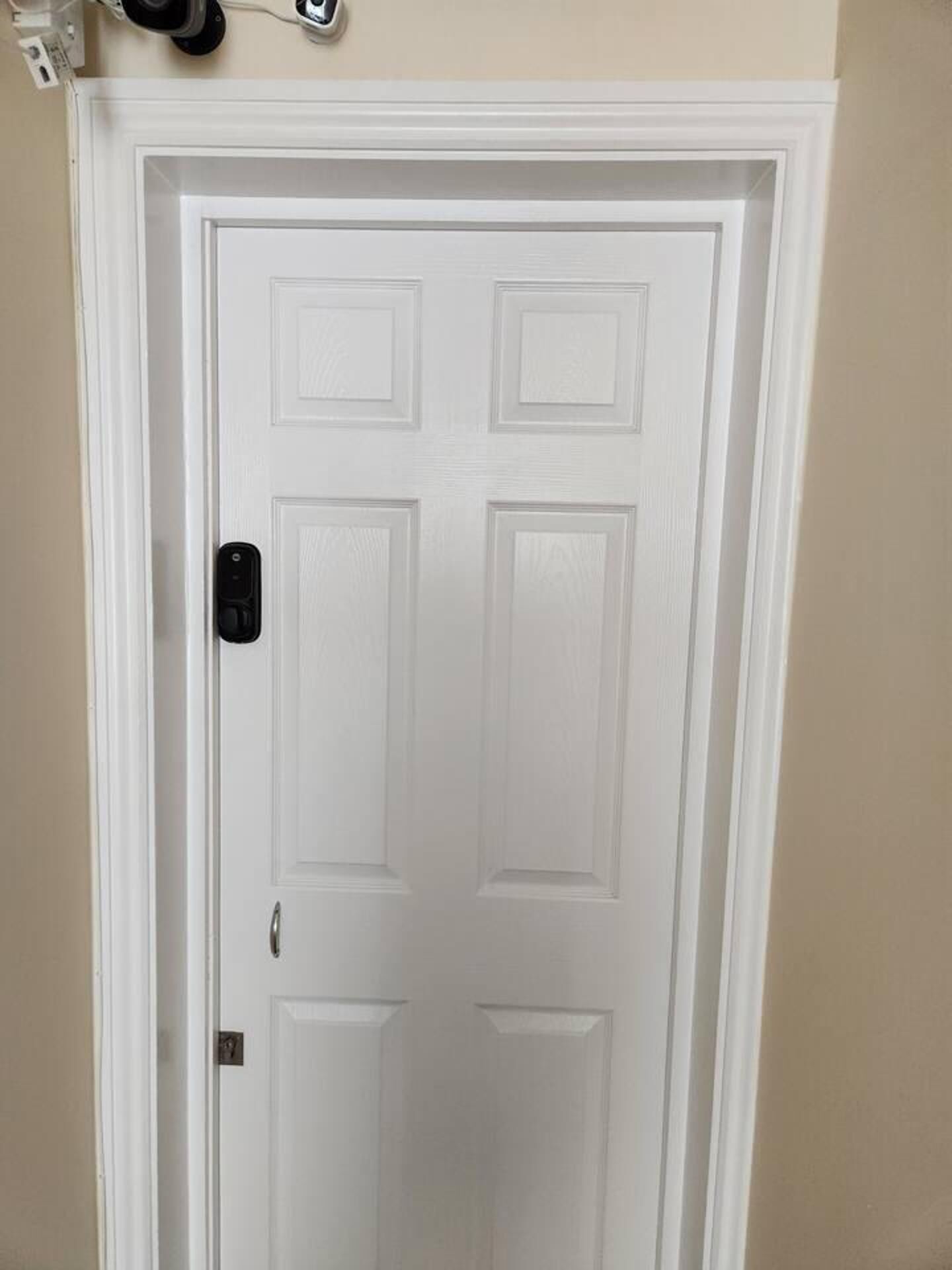A white door with a keyhole and a lock.